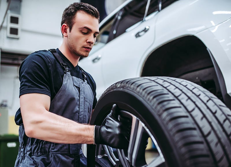 Mazda technician changing tires on a vehicle in the shop