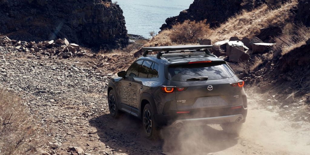 2024 Mazda CX-50 driving down a dirt road